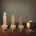 Generate an image of an antique wooden table with an old-fashioned gold-rimmed ceramic mug of coffee next to it. On the table, arrange three different sizes of money stacks denoted with cardboard cutout figures standing next to each stack. The largest stack is for 'X', the medium stack for 'Y', and the smallest stack for 'Z'. The stacks should be proportional to the ratio of 10:7:5. A subtle clue in the image could be a carefully placed pebble, signifying that Y gets slightly more than Z. Keep the image neutral-toned to emphasize the theme of mathematics and allocations.
